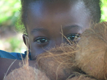 Enfant derrière des noix de coco